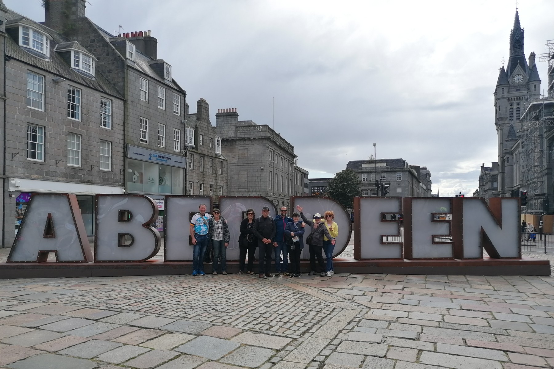 Large Aberdeen sign with group of people in front of it in the middle of street