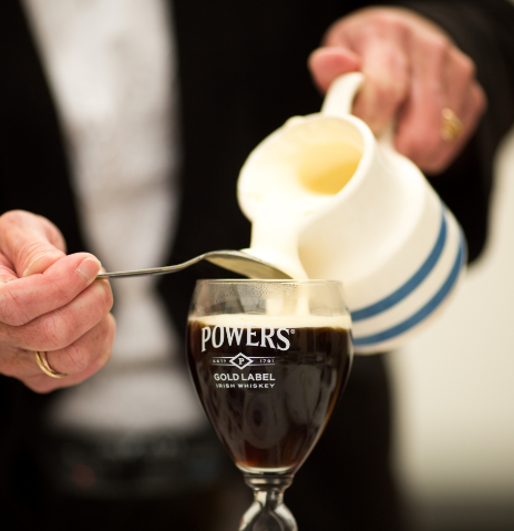 A person pouring a drink into a glass