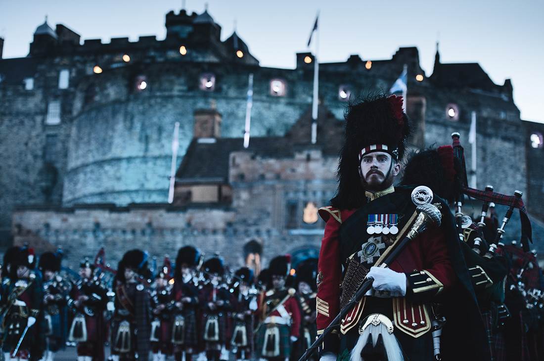 A group of men in a uniform standing in front of a castle