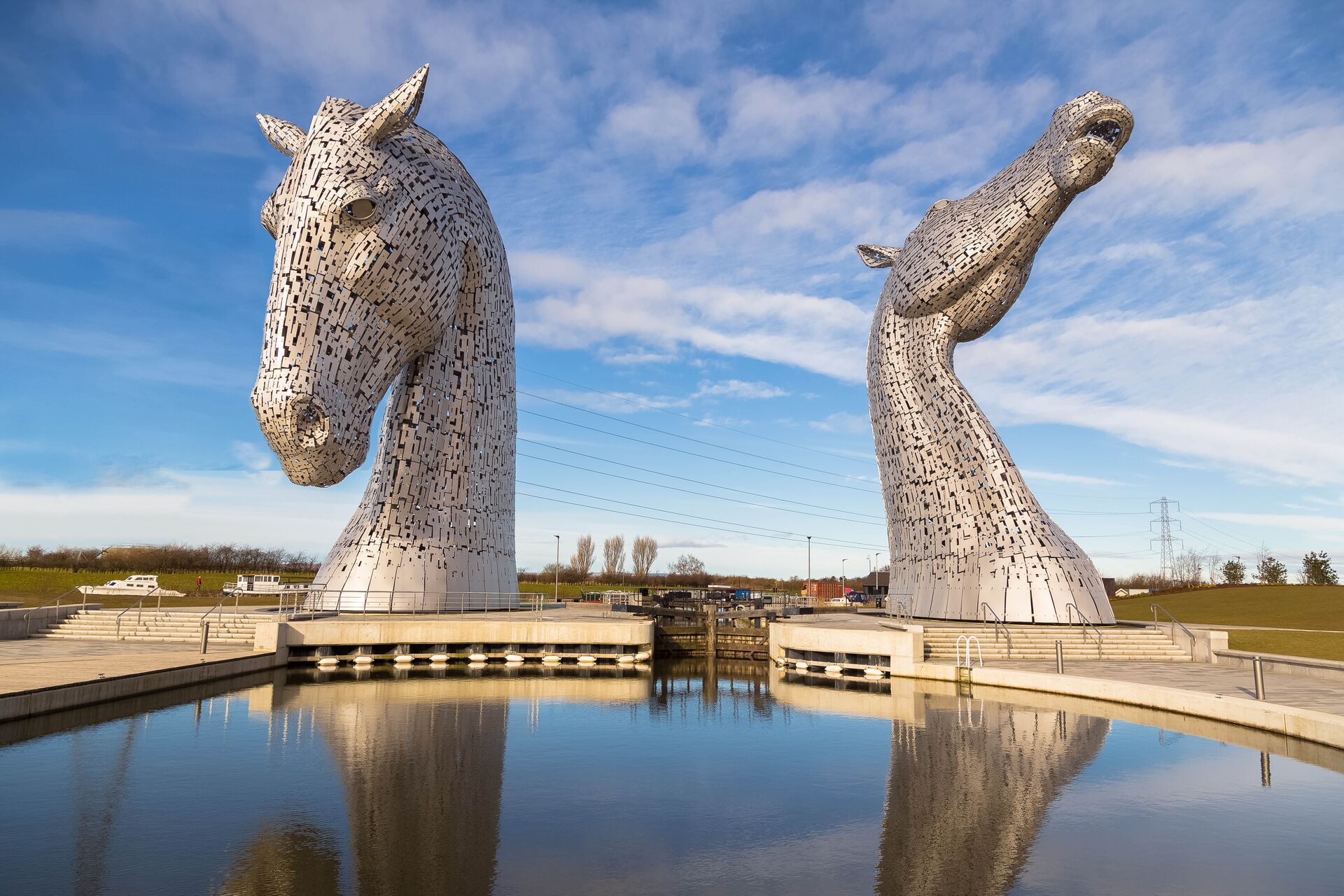 Horse sculptures behind a small bed of water 
