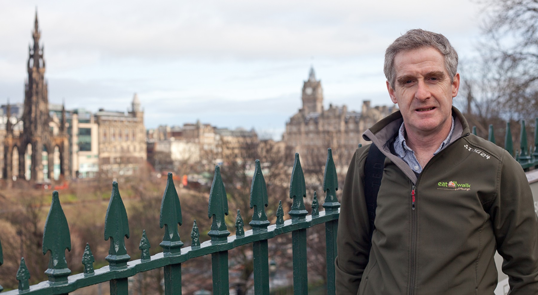 Alan Chambers Eat Walk Tours  with a view of Edinburgh in the background