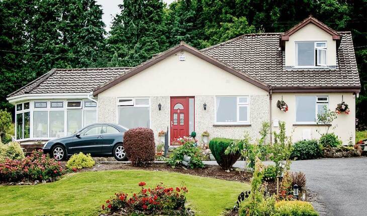 A house with a garden and a car parked in front of it