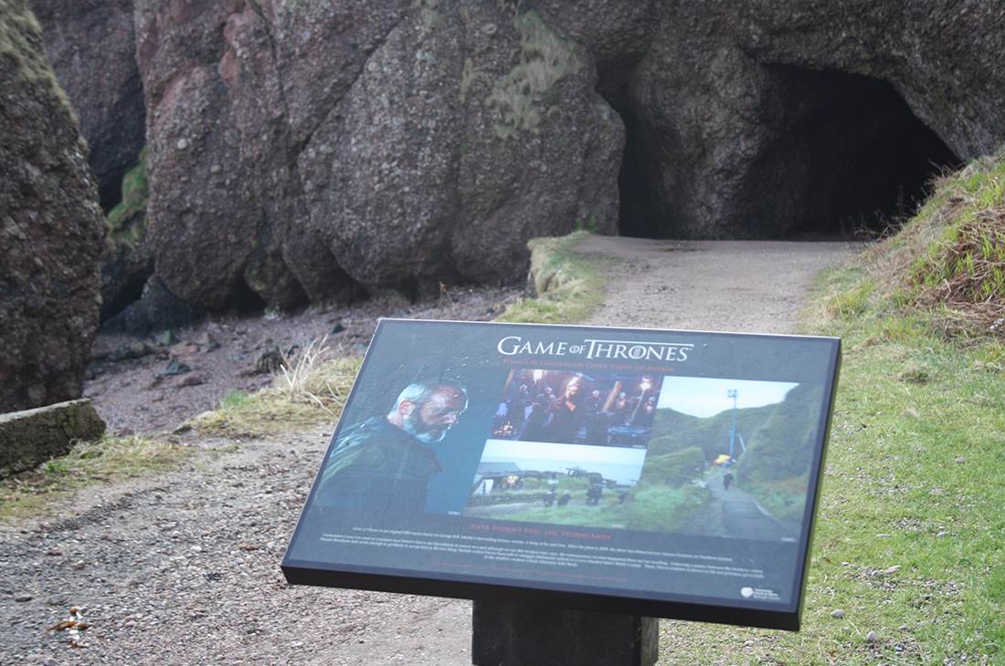 A Game of Thrones sign on the side of a dirt road 
