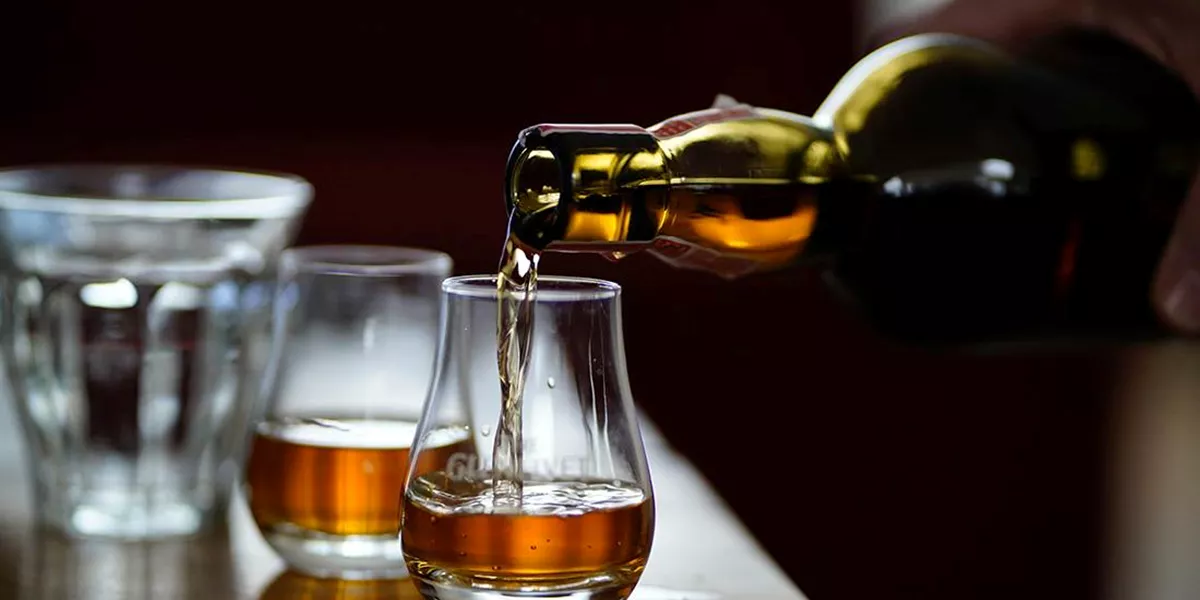 Pouring whiskey in the glass in Oban Distillery in Scotland