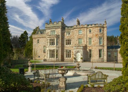 A large stone building with a fountain in front of it