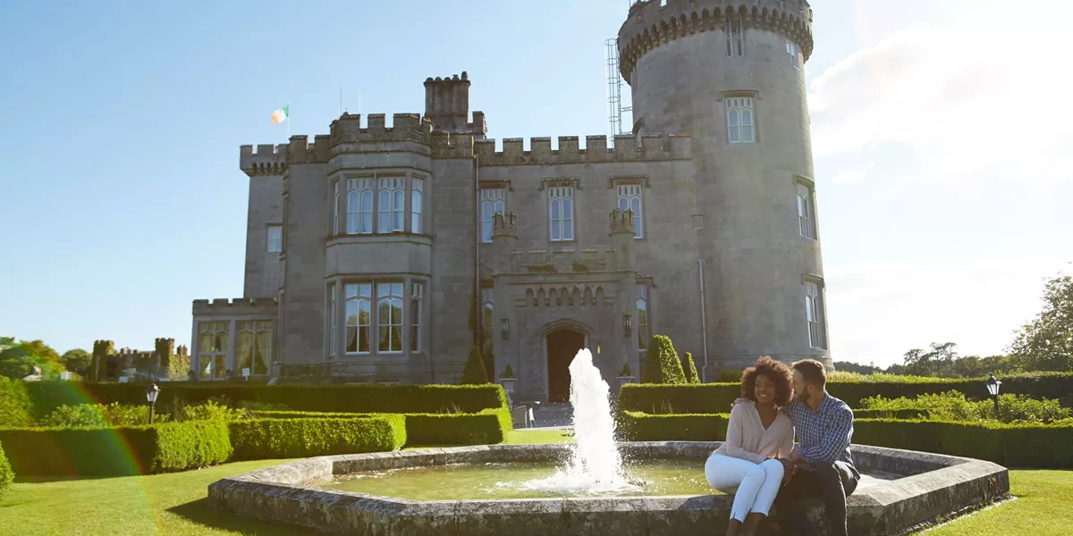 A couple sitting next to the fountain in front of Dromoland Castle in Ireland.