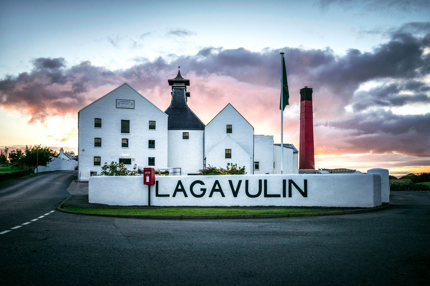 White building of Lagavulin Distillery from the front with red post box