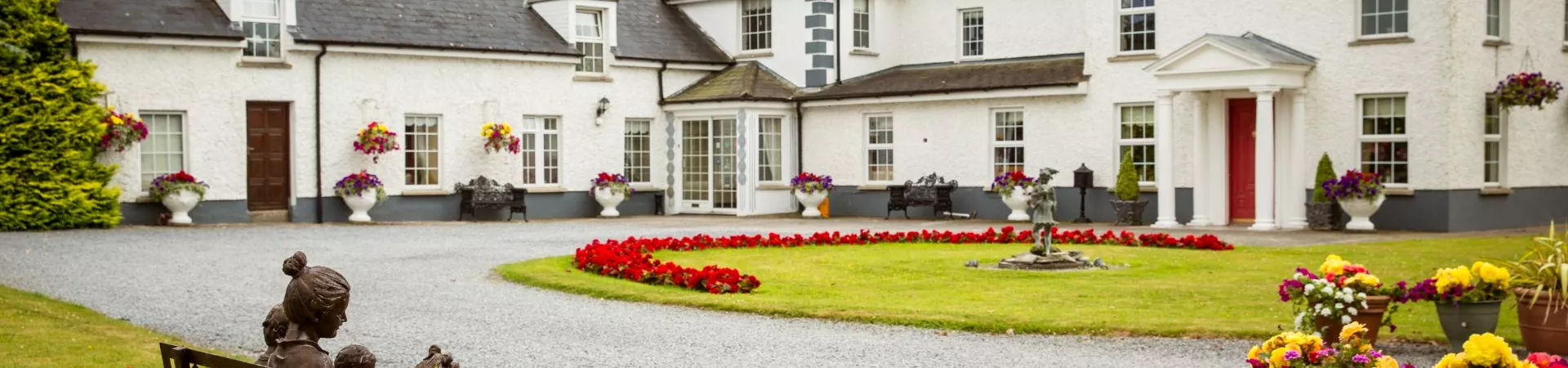 A large white house with a garden in front of it