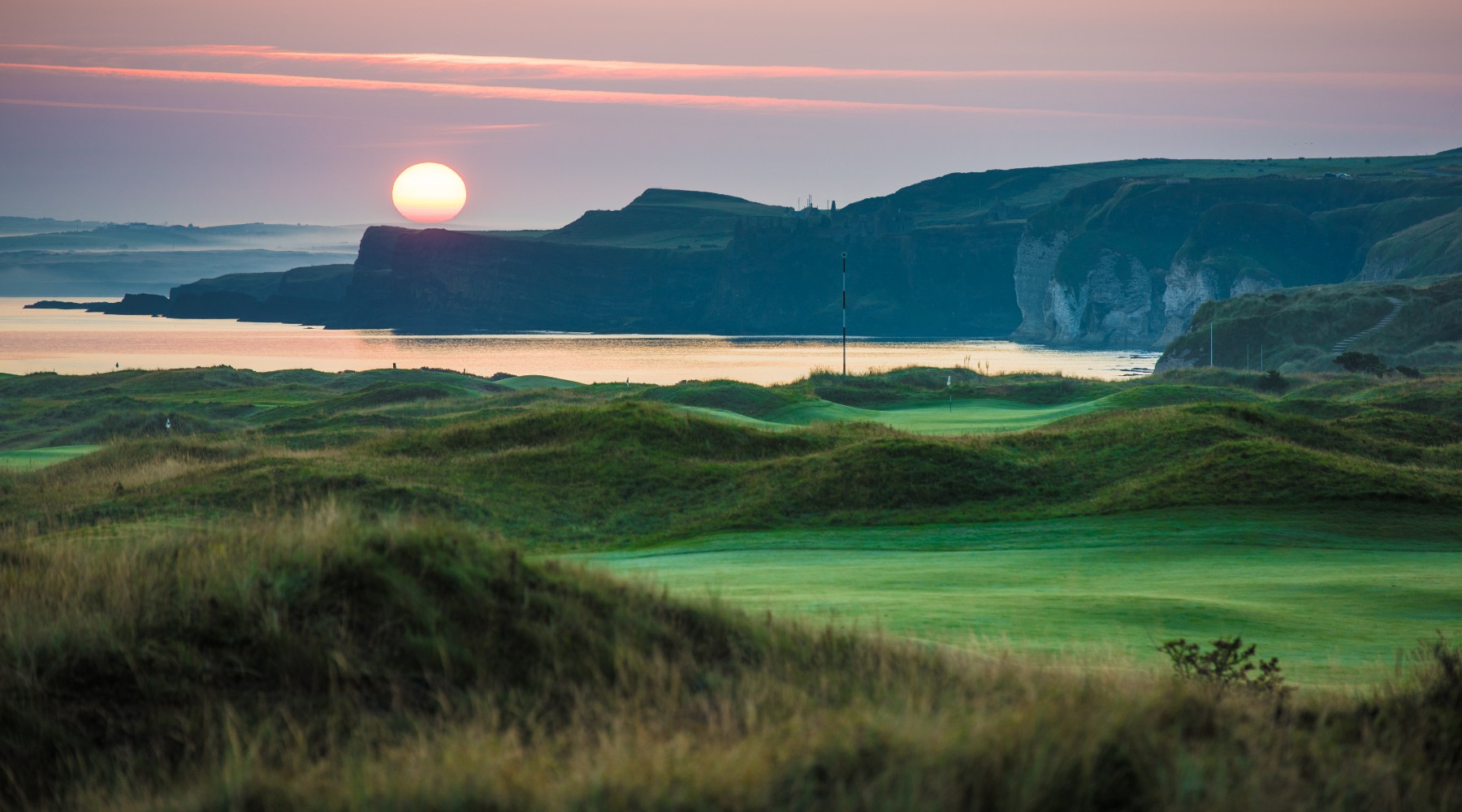 The sun is setting over a golf course