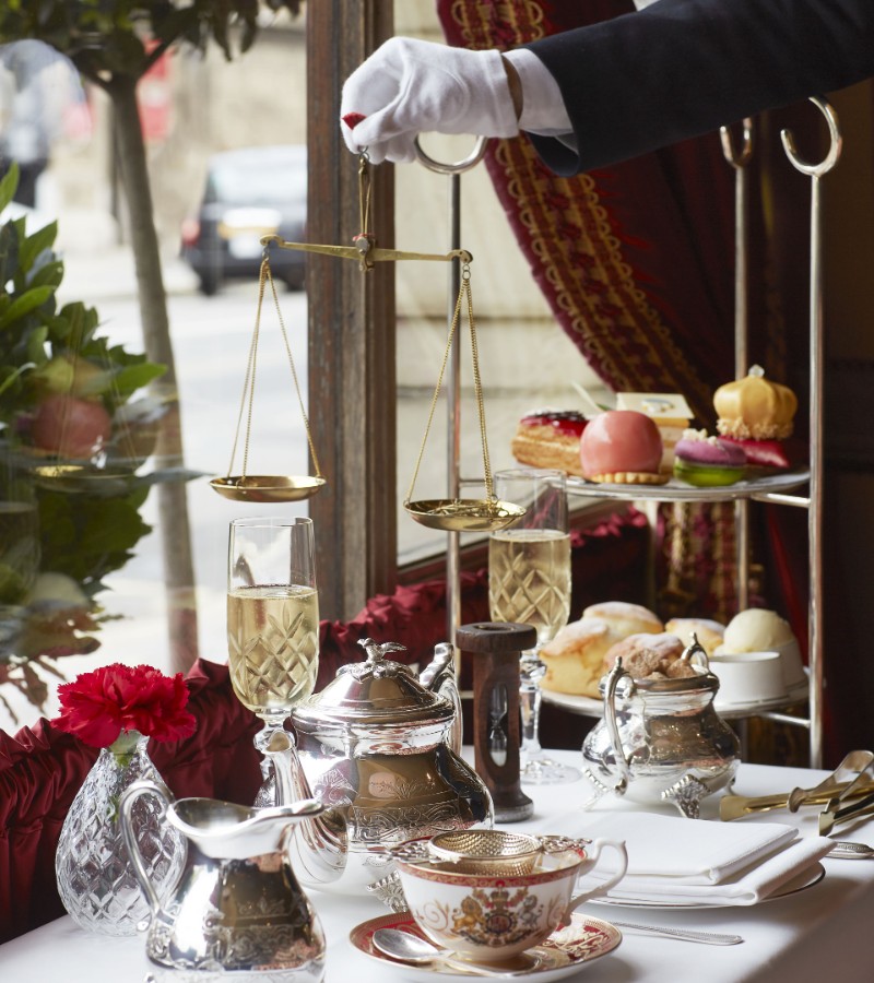A table topped with a tray of food and tea next to a window