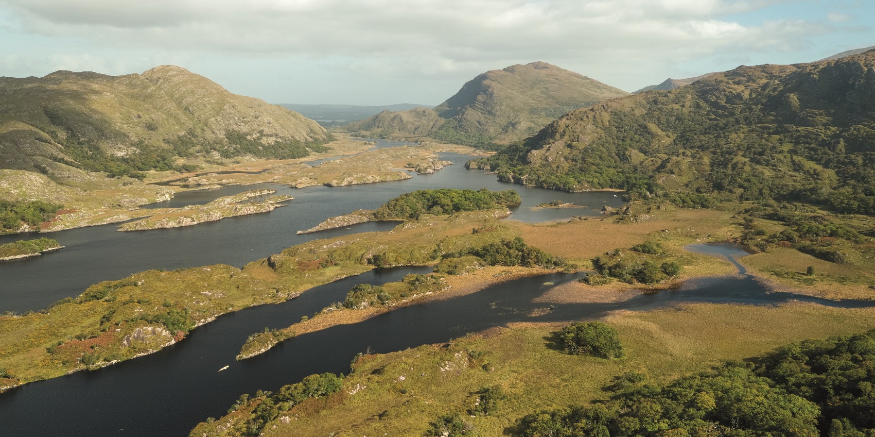 Aerial view of Killarney National Park with hills in the distance and a series of lakes in the foreground.