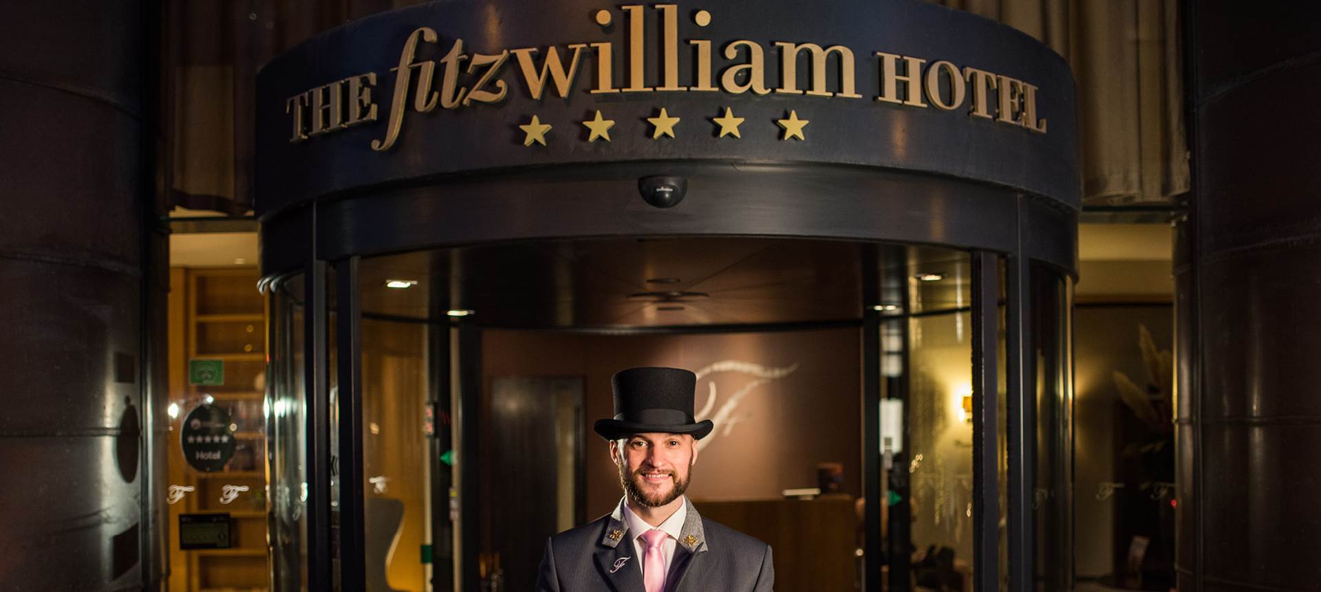 A man standing in front of The Fitzwilliam Hotel in Belfast