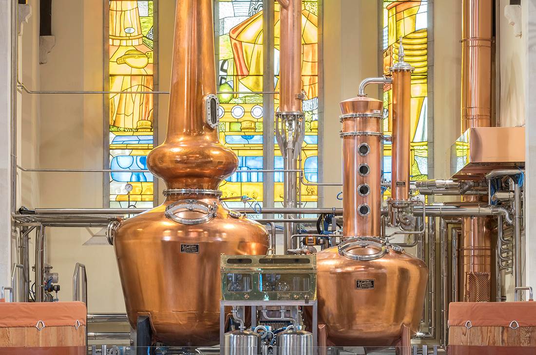 Pot still and piping in stained glass room