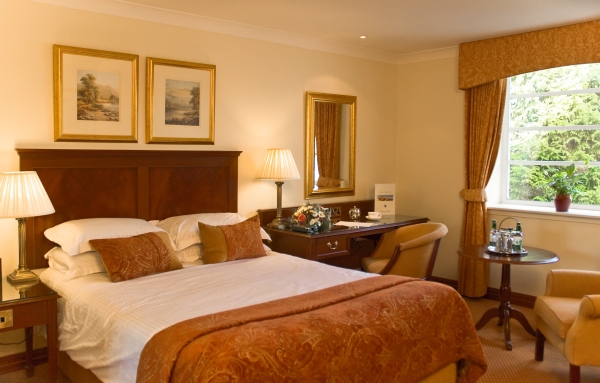 Classic double bedroom with paintings on the wall in Drumossie hotel in Inverness, Scotland