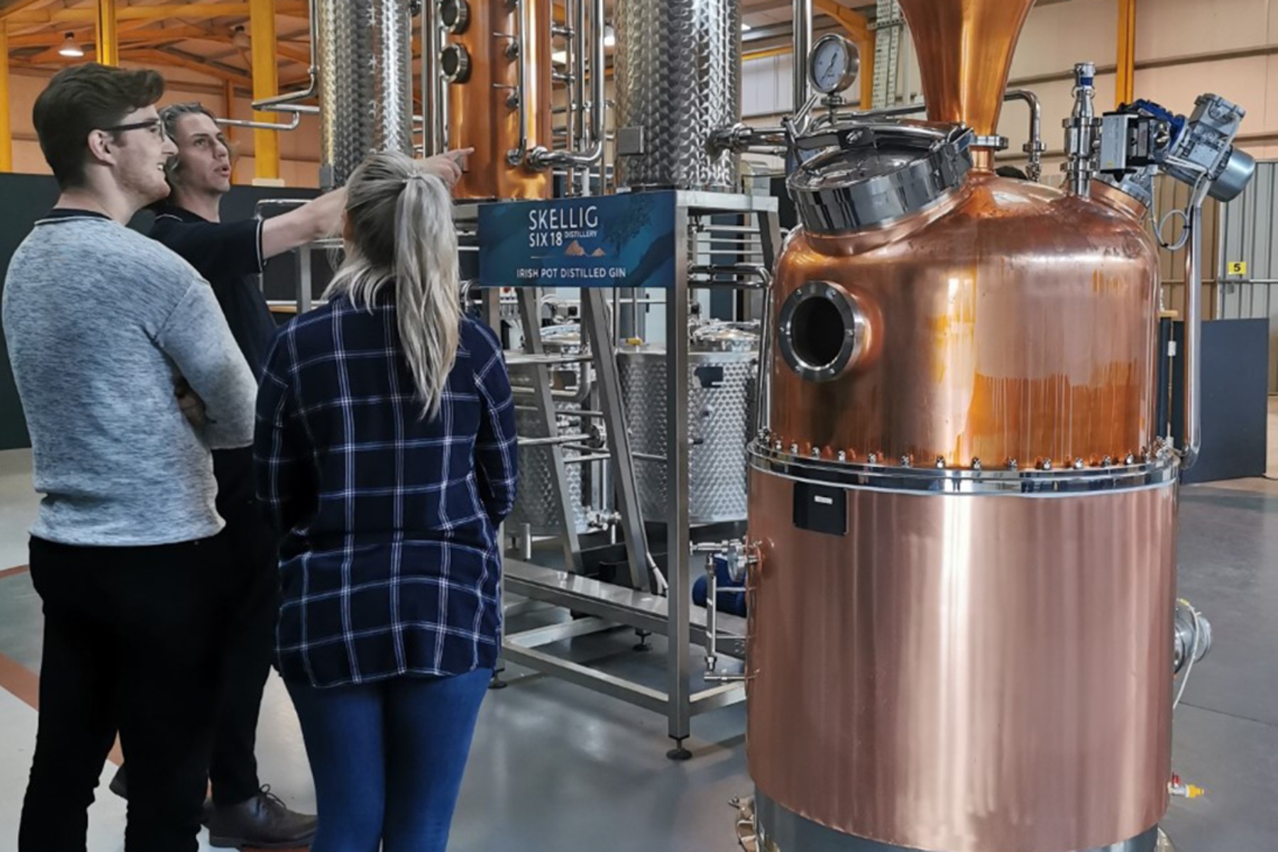 Two people with their tour guide at Skellig Six18 Distillery