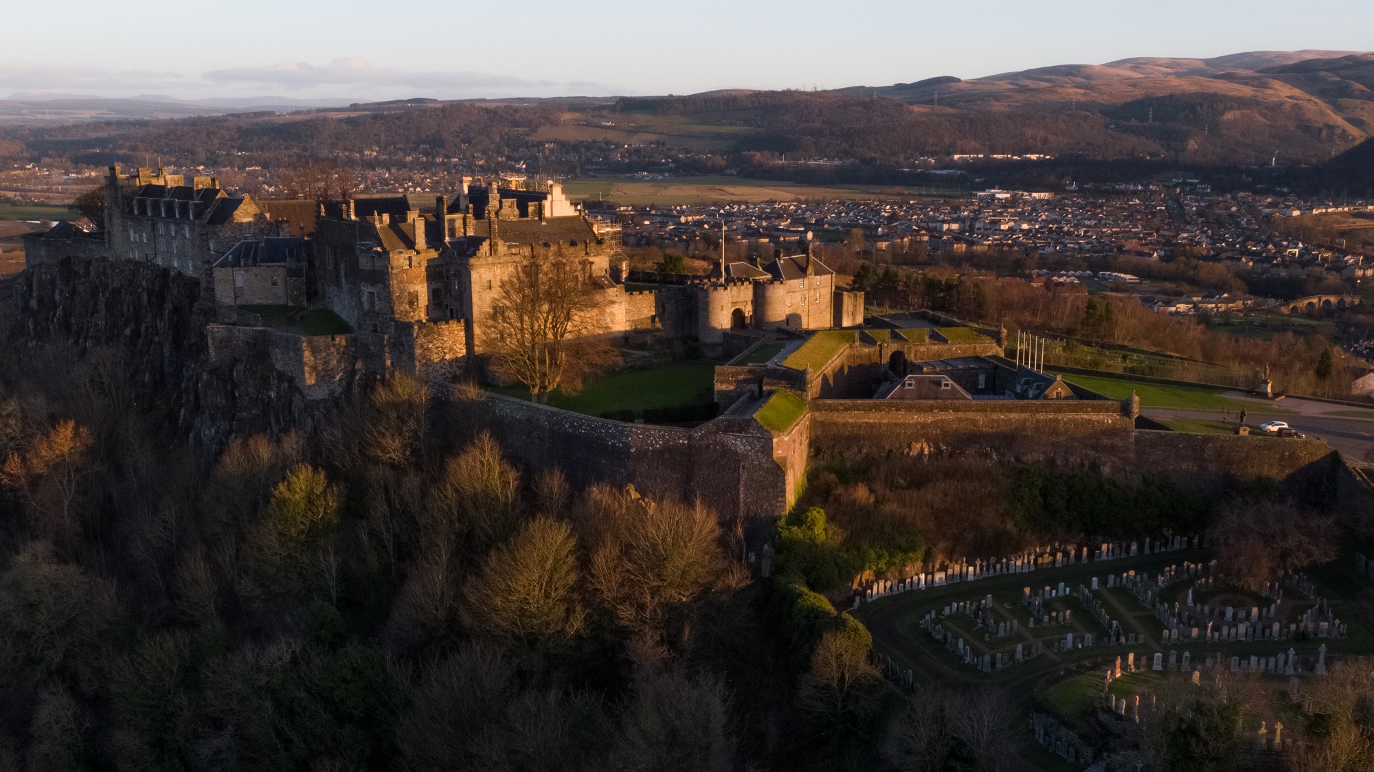 An aerial view of a castle with a buildings in the foreground