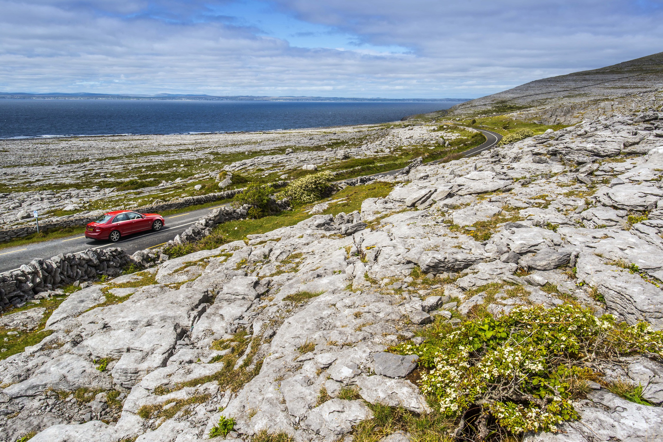 A car driving the Wild Atlantic Way along the Burren Island