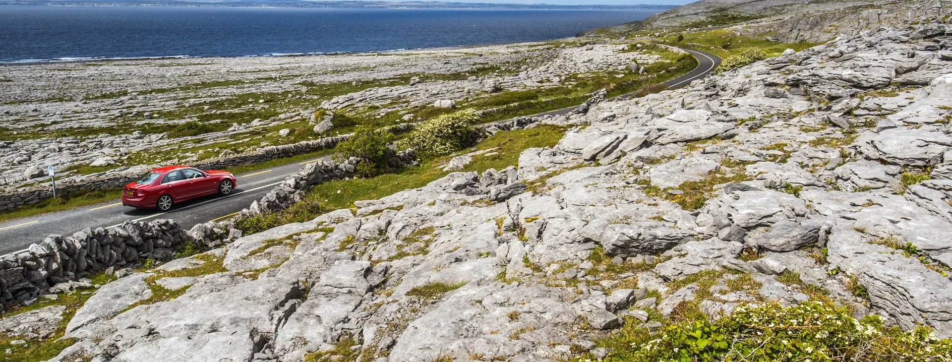 A car driving the Wild Atlantic Way along the Burren Island