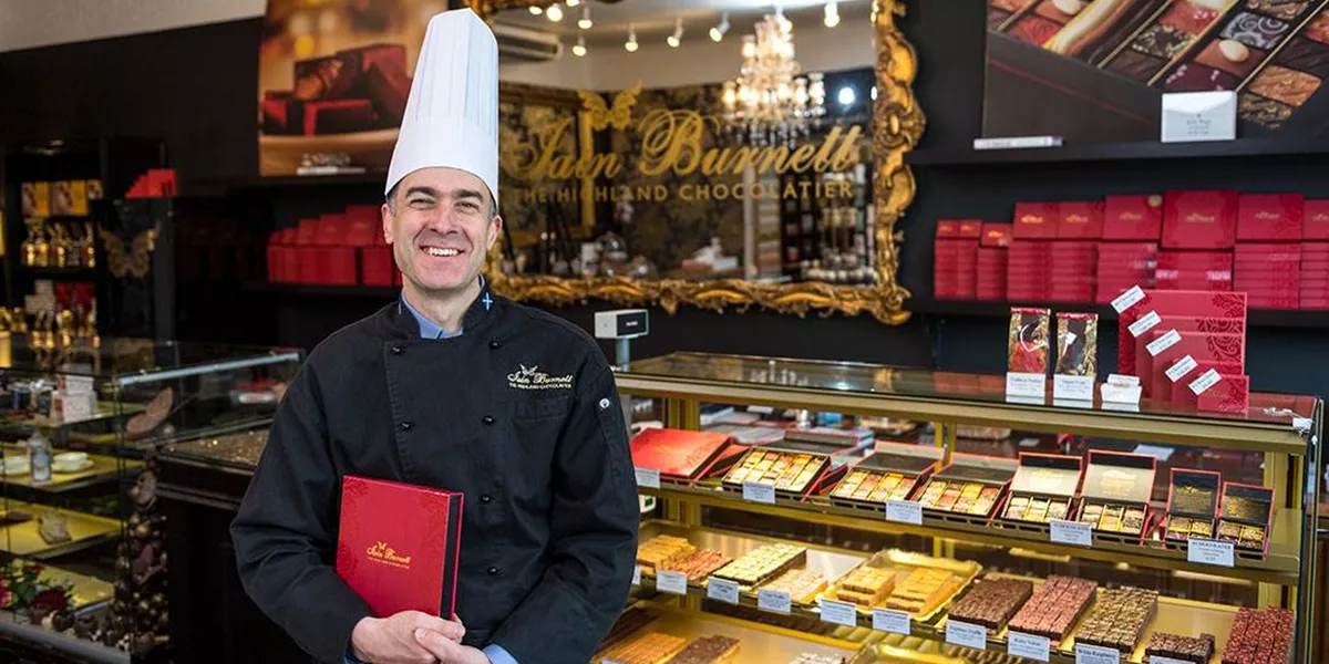 A chocolatier posing with chocolate display