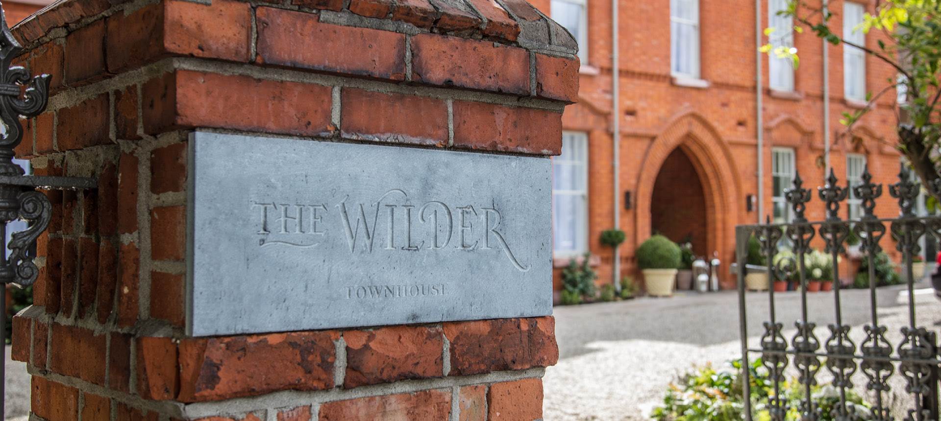 A brick wall with a sign that says The Wilder