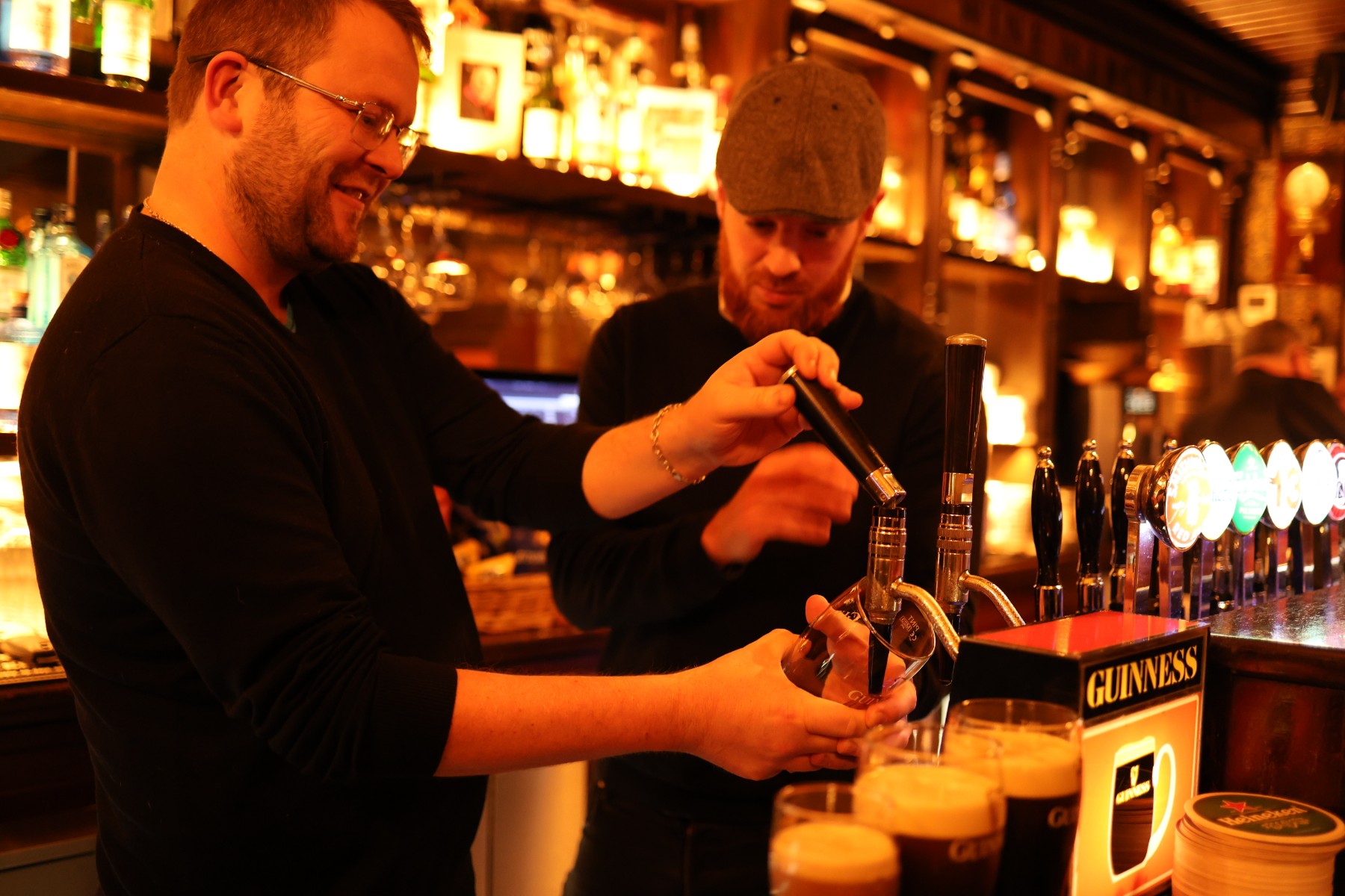 Barmen pulling pints at Guinness Brewery