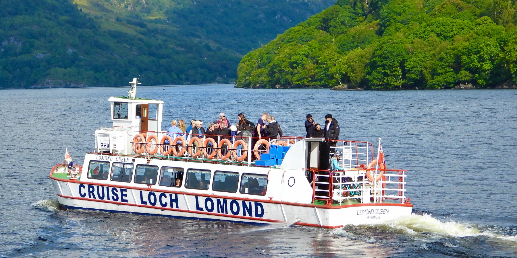 A boat cruise on a lake with mountains in the background 