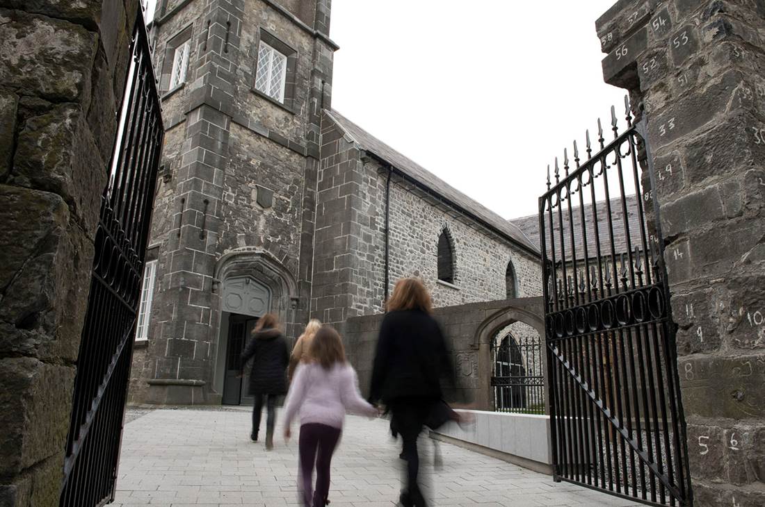 People walking through the gate towards the old building