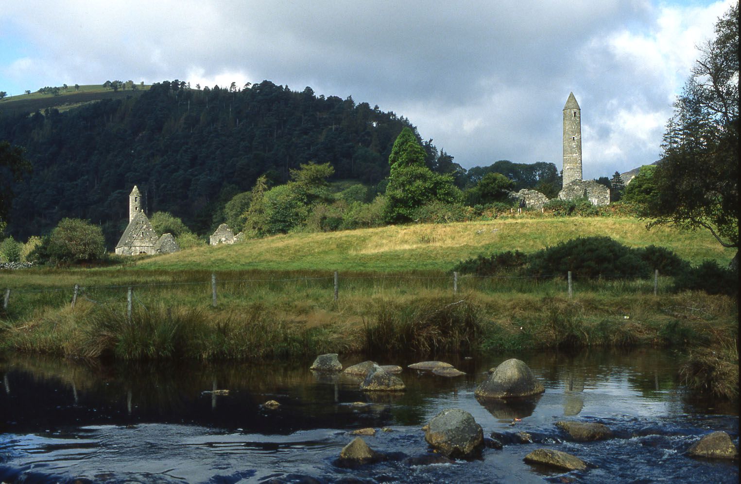 A river running through a lush green countryside in Glendalough