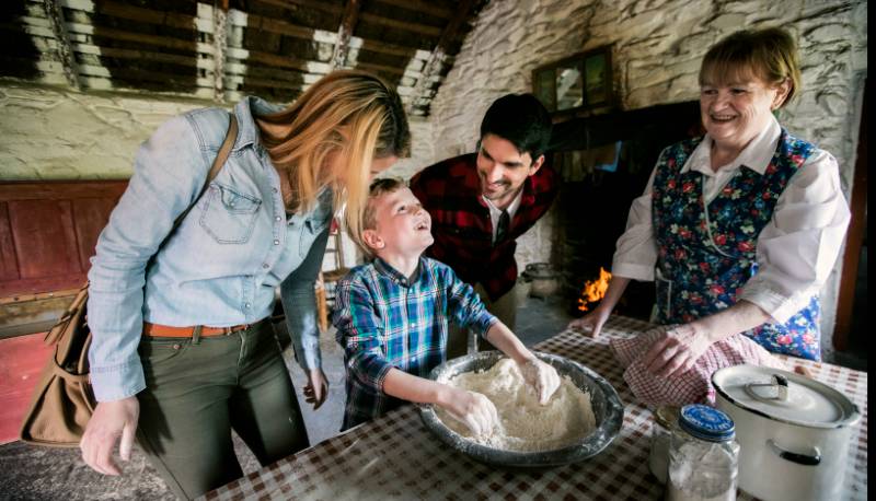 boy baking in a farm house with adults at muckross farm