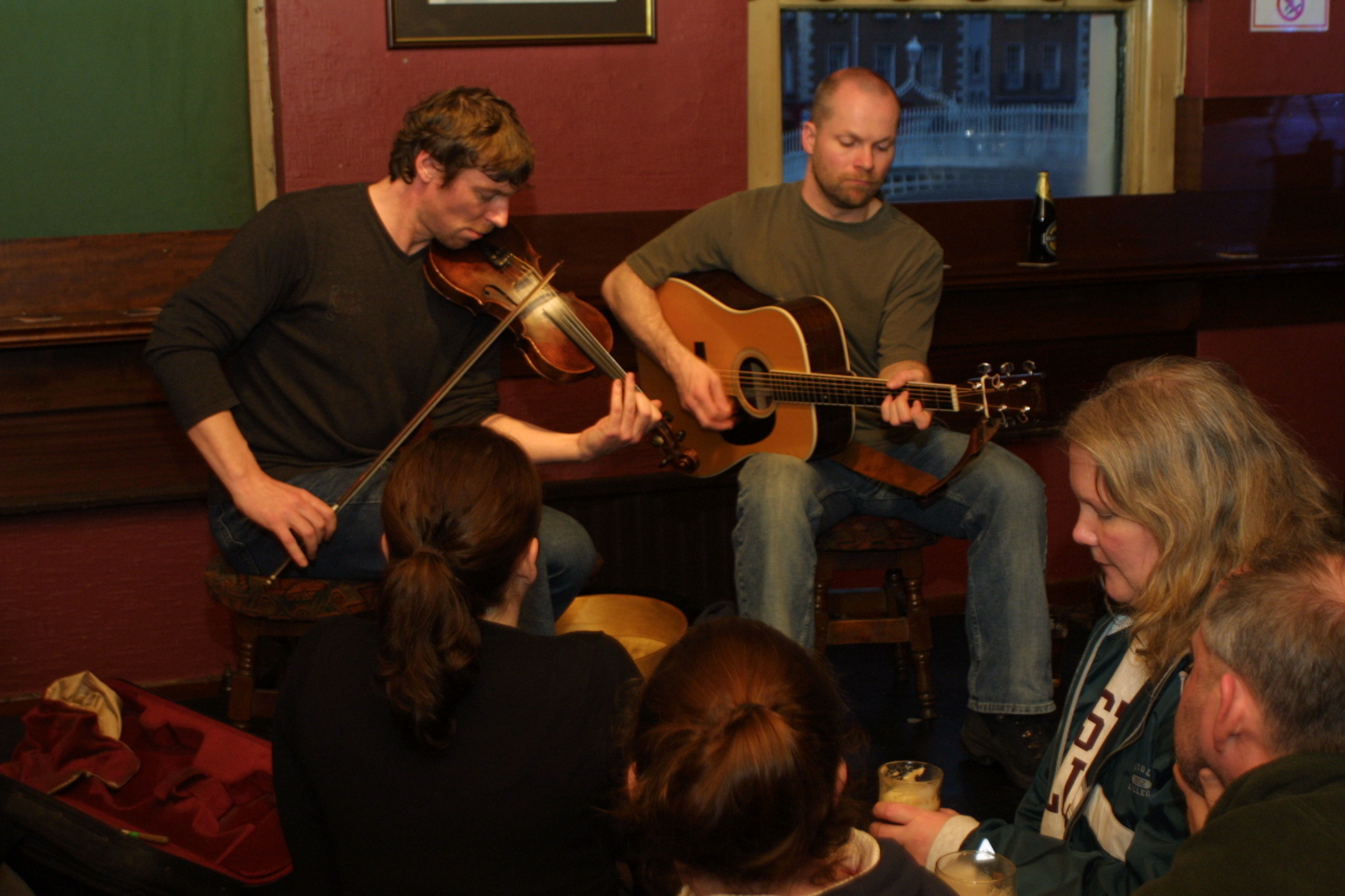 Two men playing the guitar and violin