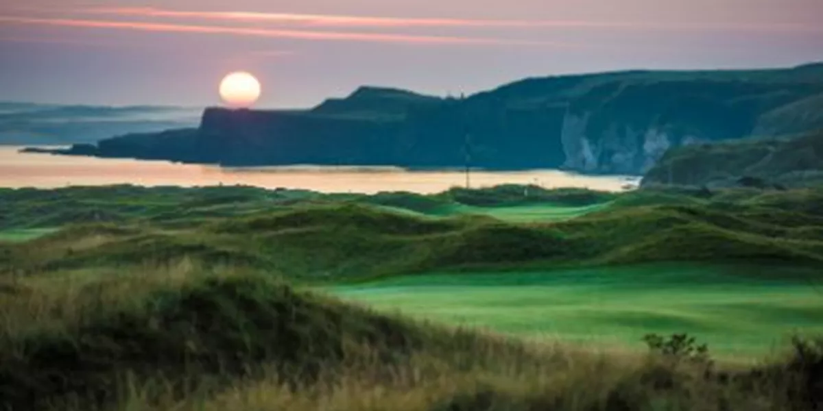 The sun is setting over a golf course
