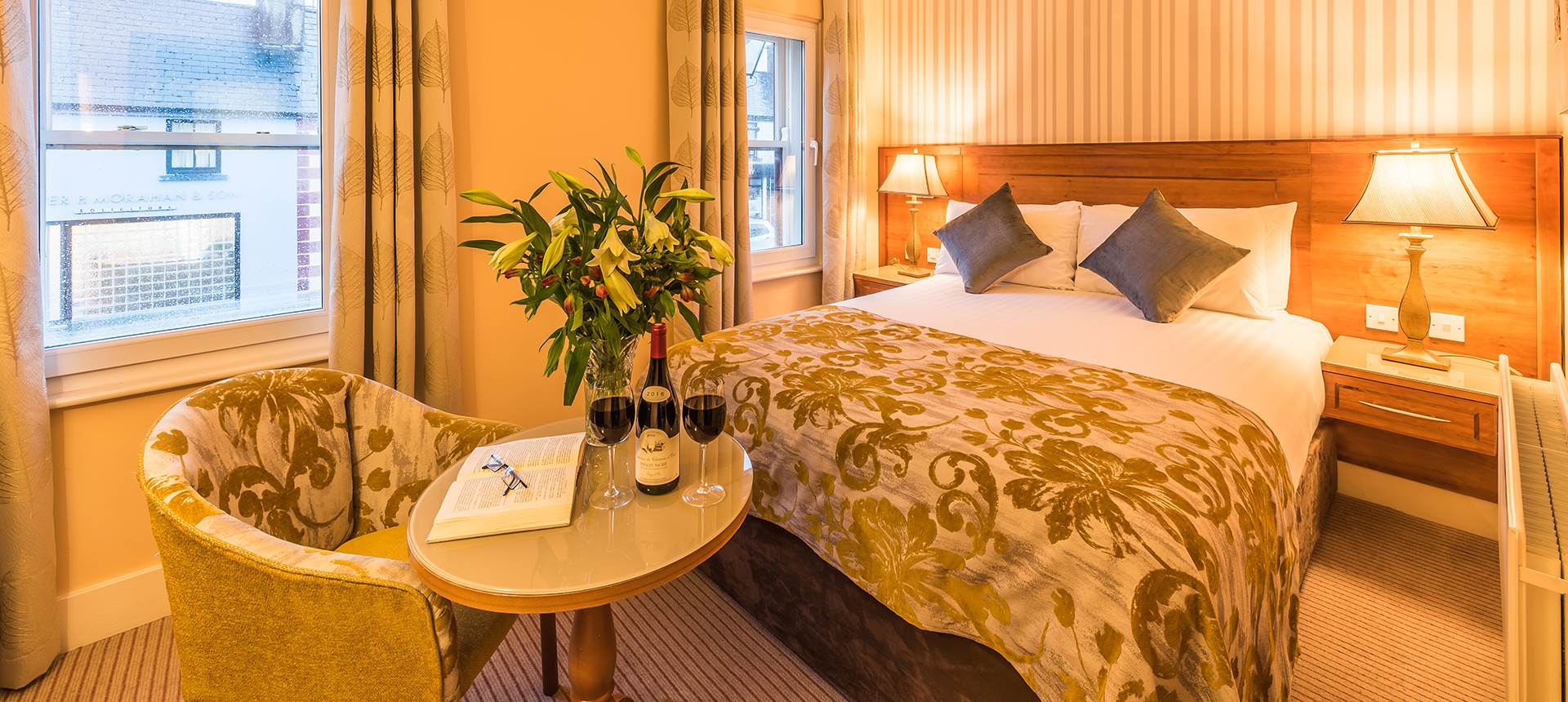 A bedroom with a neatly made bed and a chair 