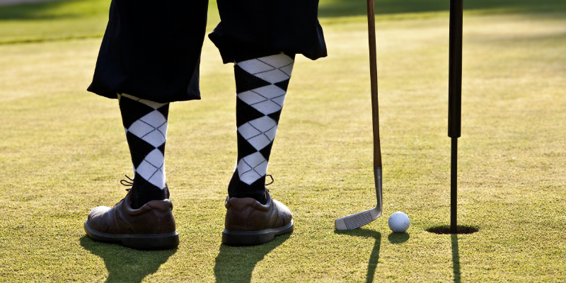 Golfer with checkered socks on green