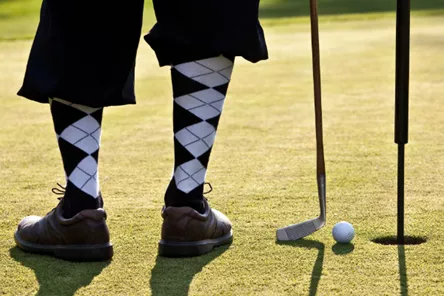 Golfer with checkered socks on green