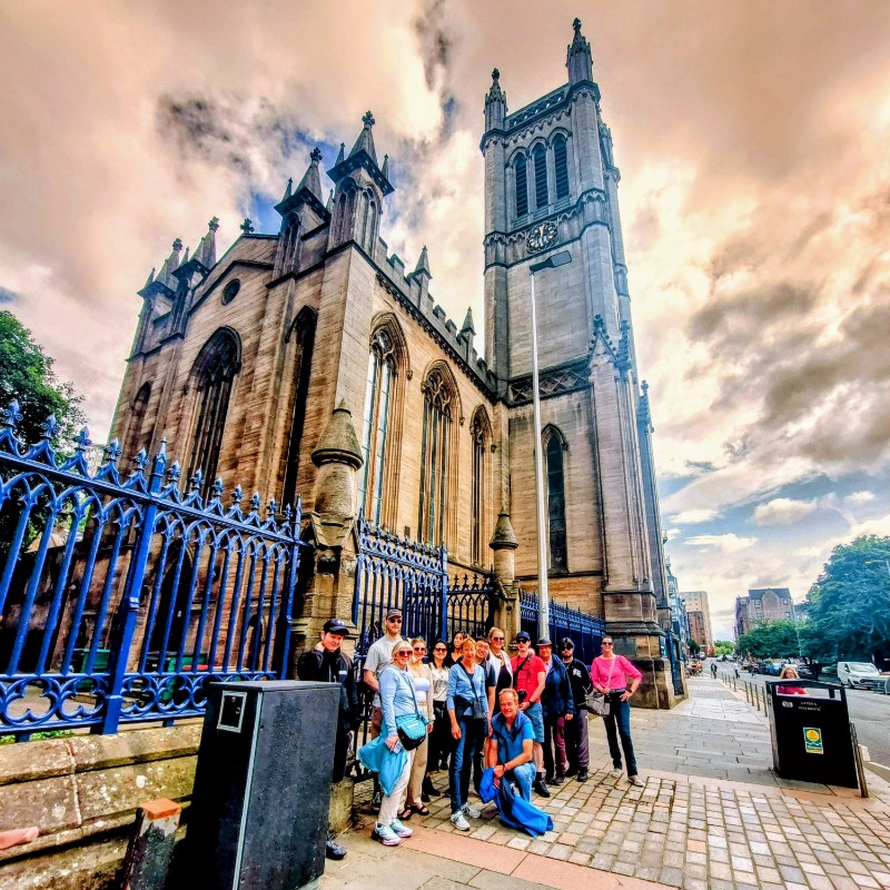 A group of tourists posing for a photo during Glasgow Walking Tour