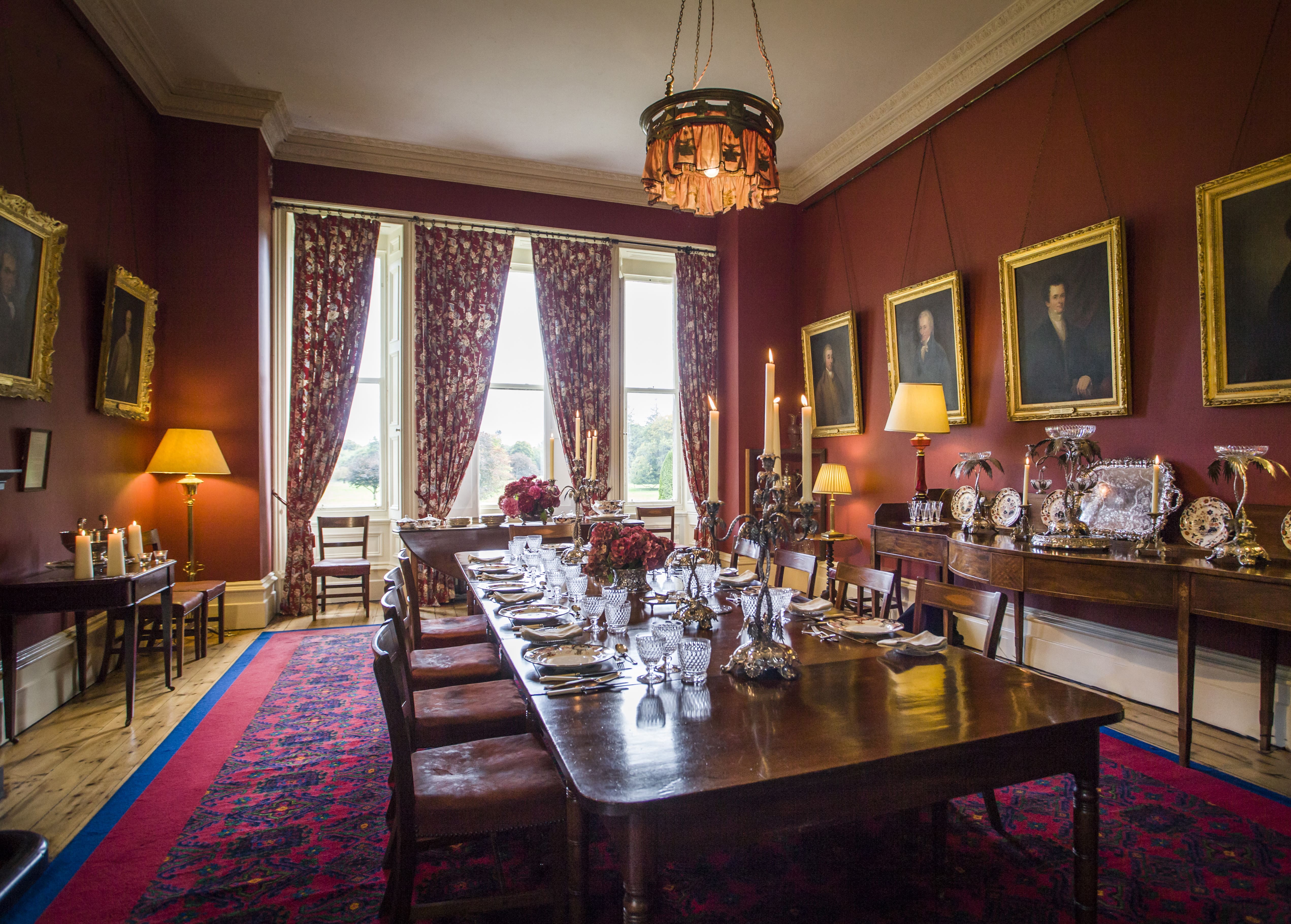 A dining room with a table, chairs, and pictures on the wall at Clonalis House in Roscommon 