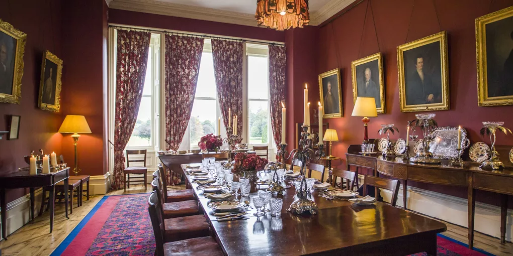 A dining room with a table, chairs, and pictures on the wall at Clonalis House in Roscommon