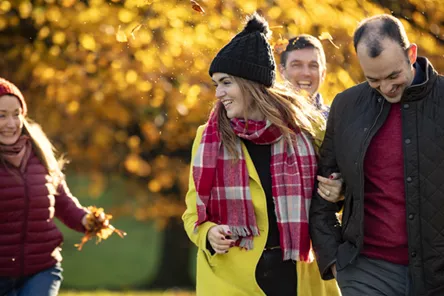 Family throwing leaves in the autumn