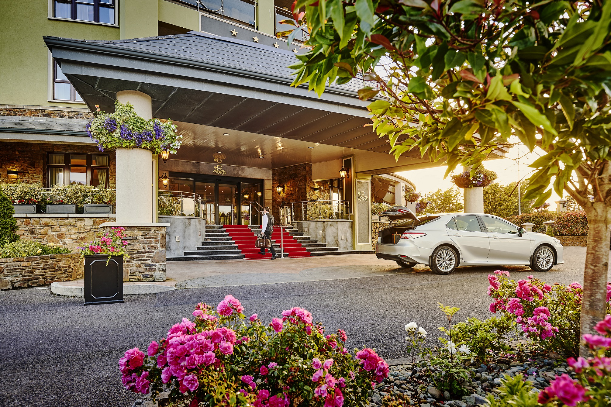 A white car parked in front of a hotel