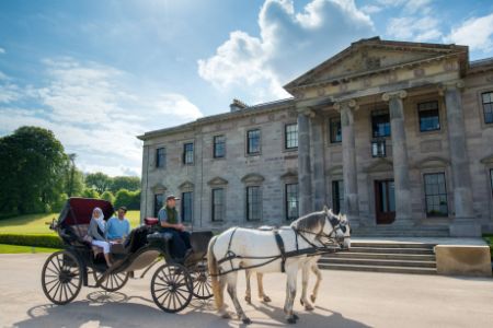 A horse drawn carriage in front of a large building
