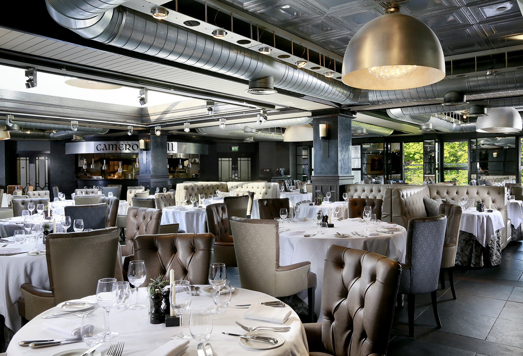 A restaurant with tables and chairs with white tablecloths