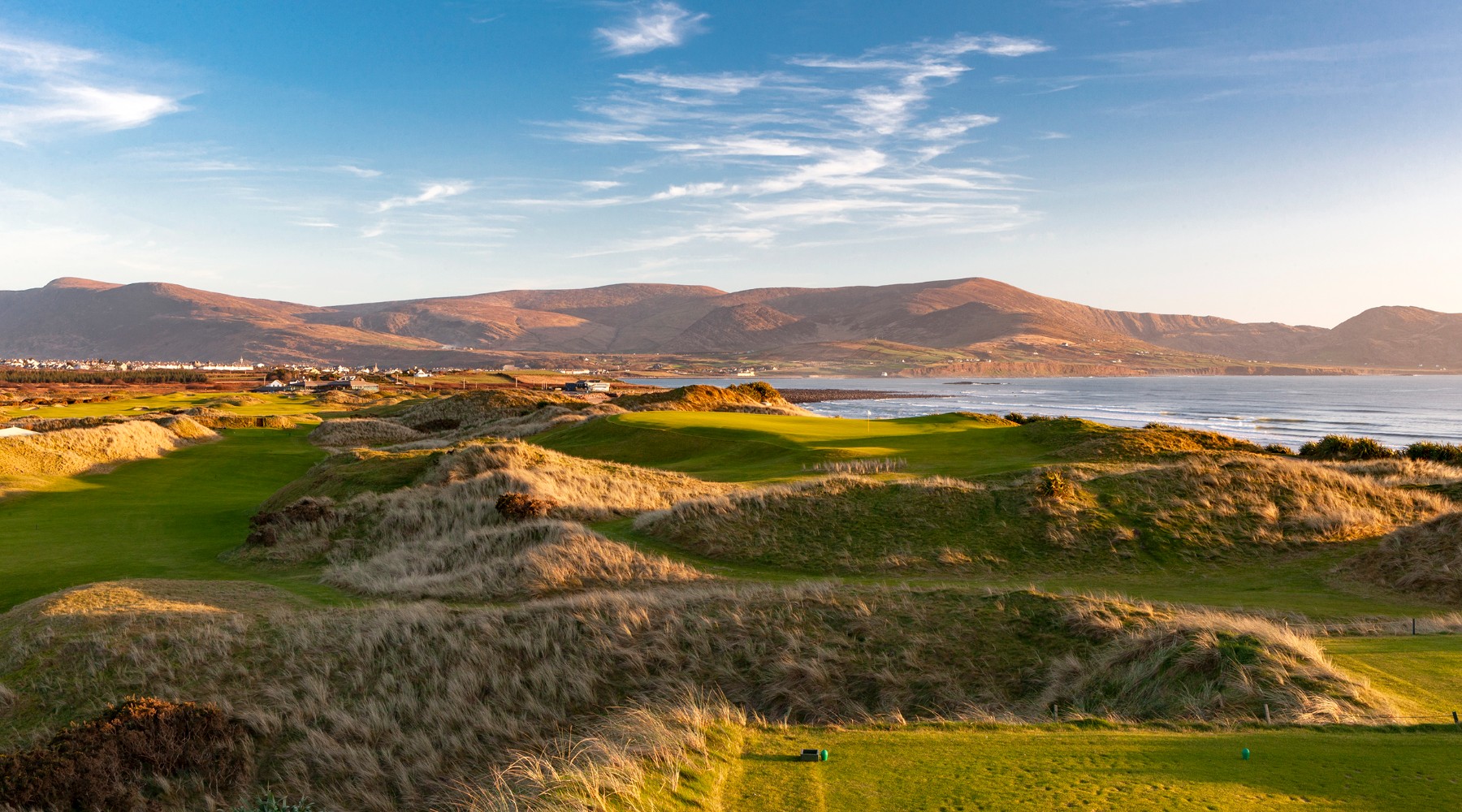 A view of a golf course with mountains in the background
