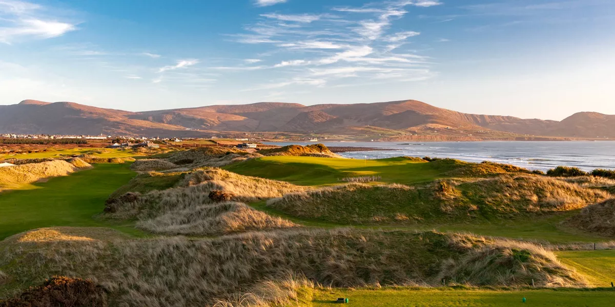 A view of a golf course with mountains in the background