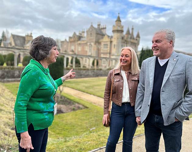 A group of people standing in front of a castle