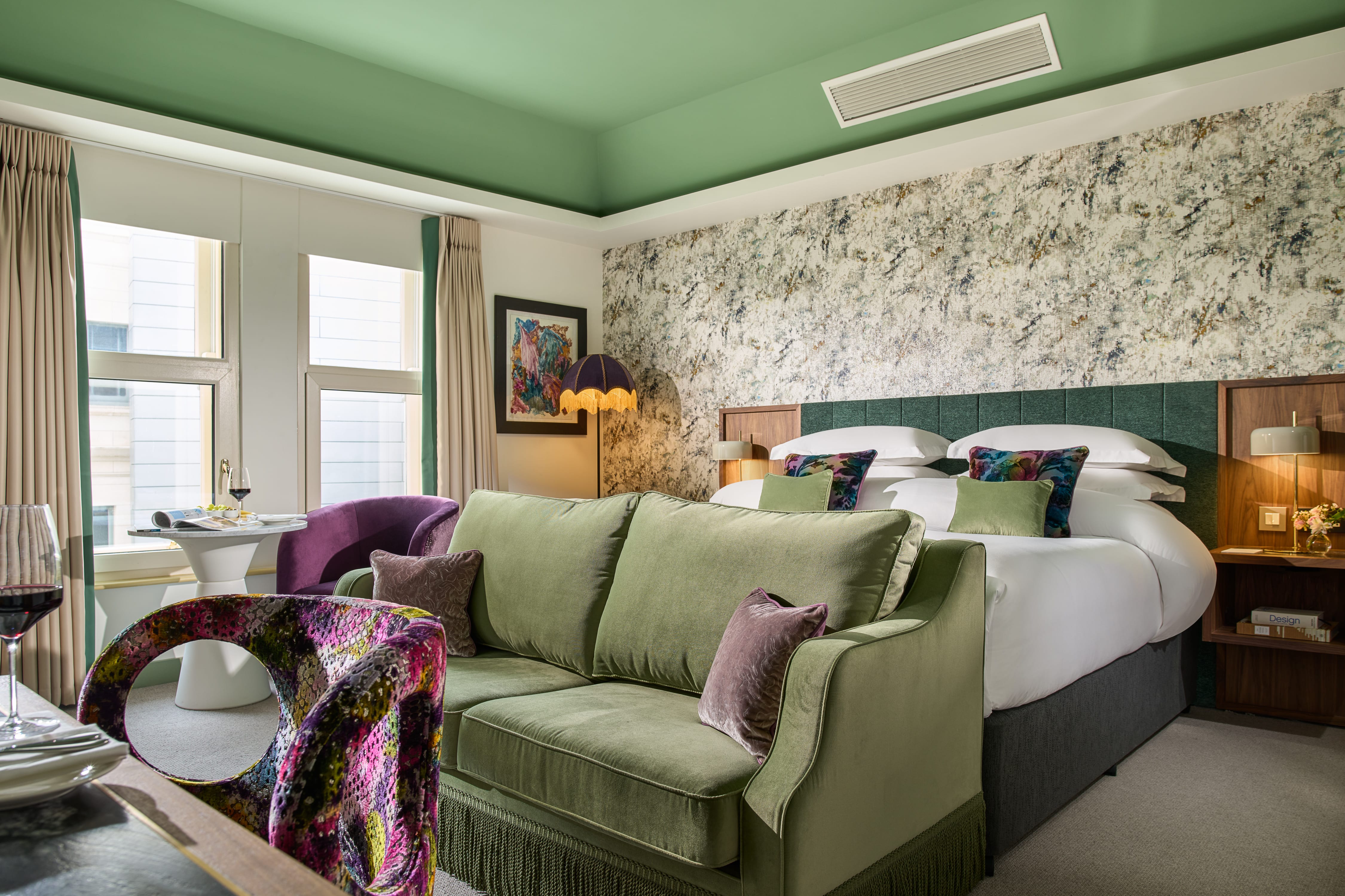 Deluxe king bedroom with green sofa in Dylan Hotel in Dublin