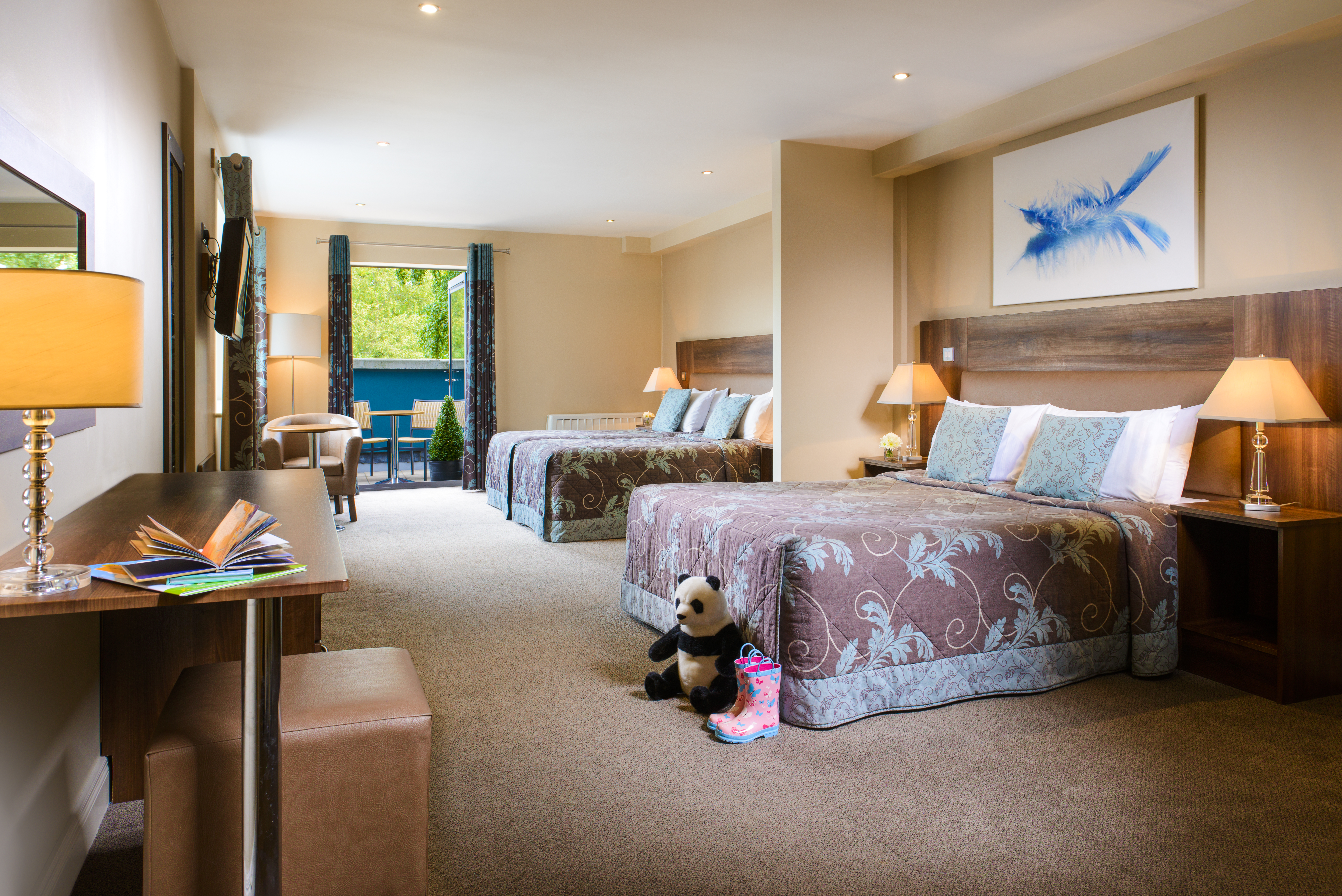 A hotel room with two beds and a teddy bear