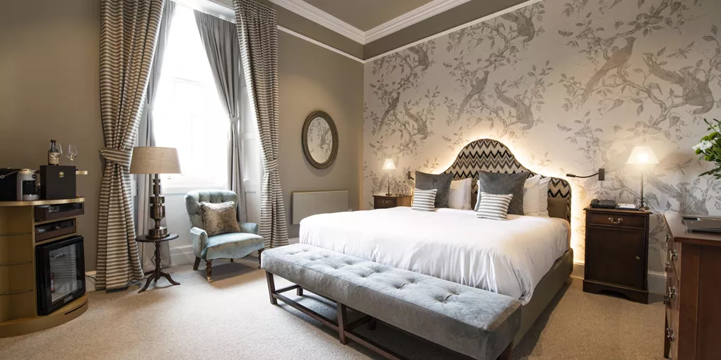 Superior room with a large bed and floral wallpaper in SCHLOSS Roxburghe in Kelso, Scotland