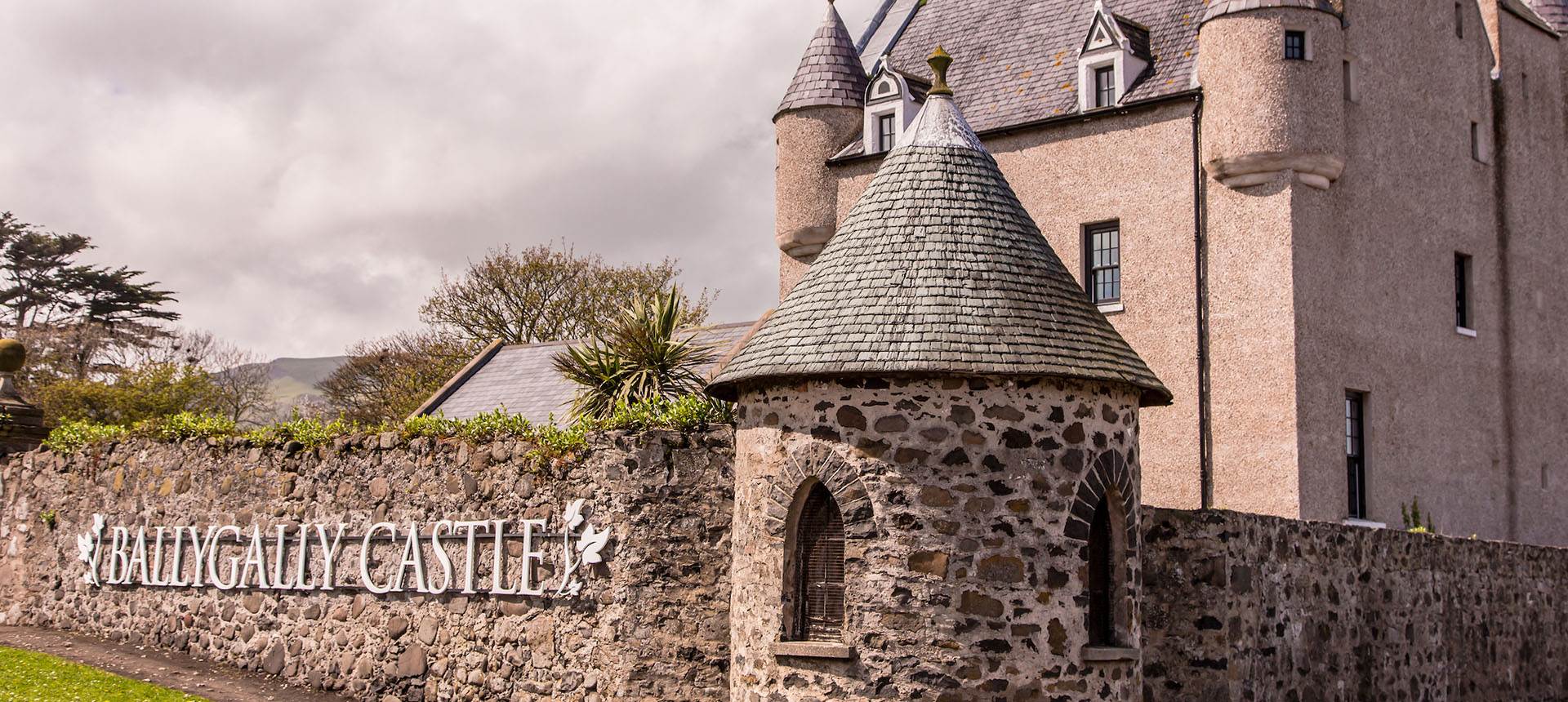 Ballygally Castle exterior with a stone fence around it