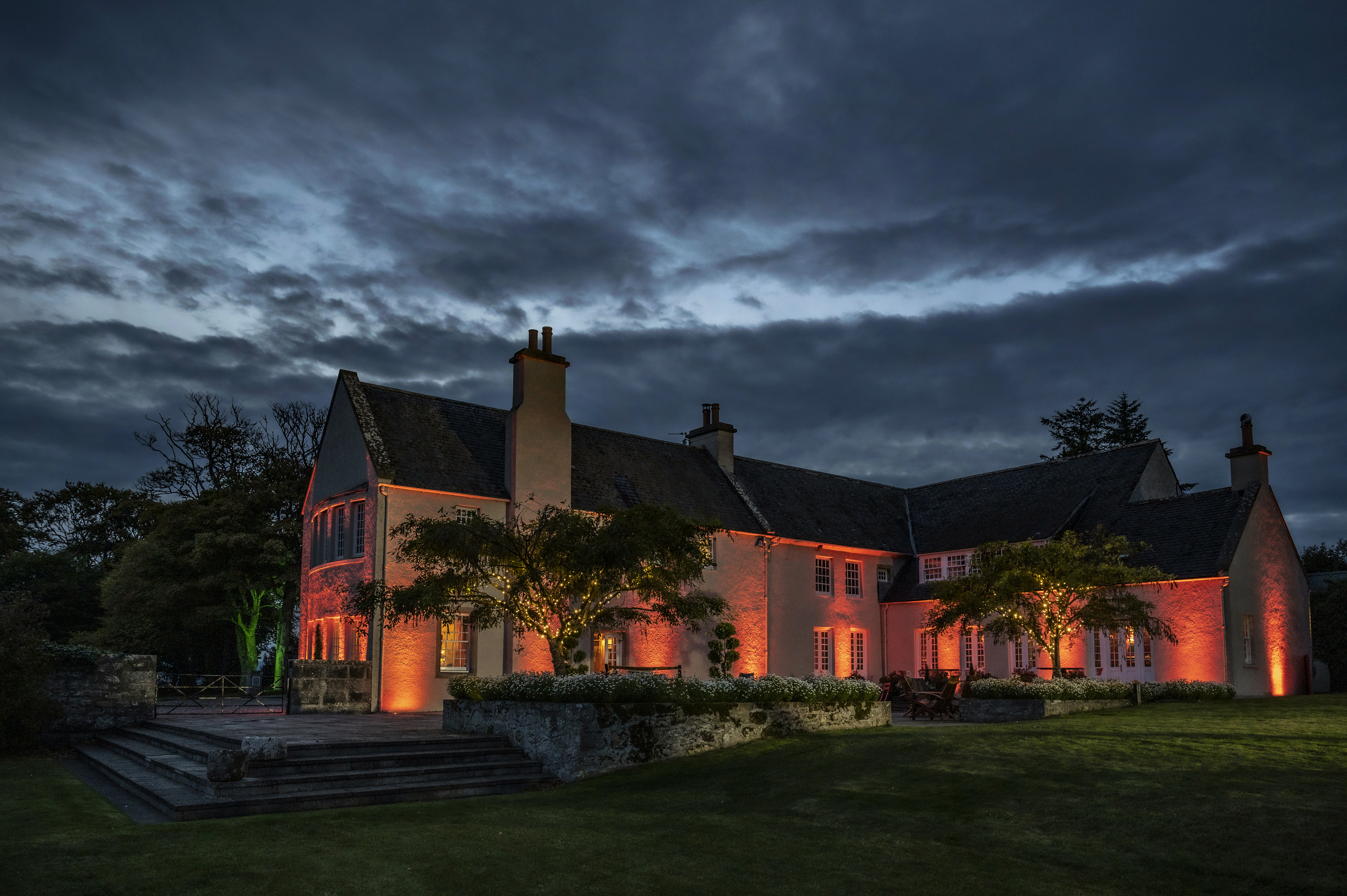 A large house with a lot of windows lit up at night