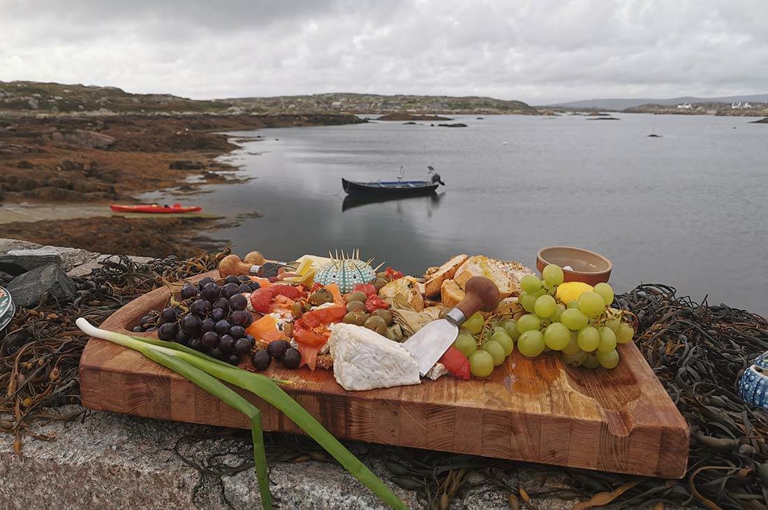 A cheeseboard with lake and canoes in the background